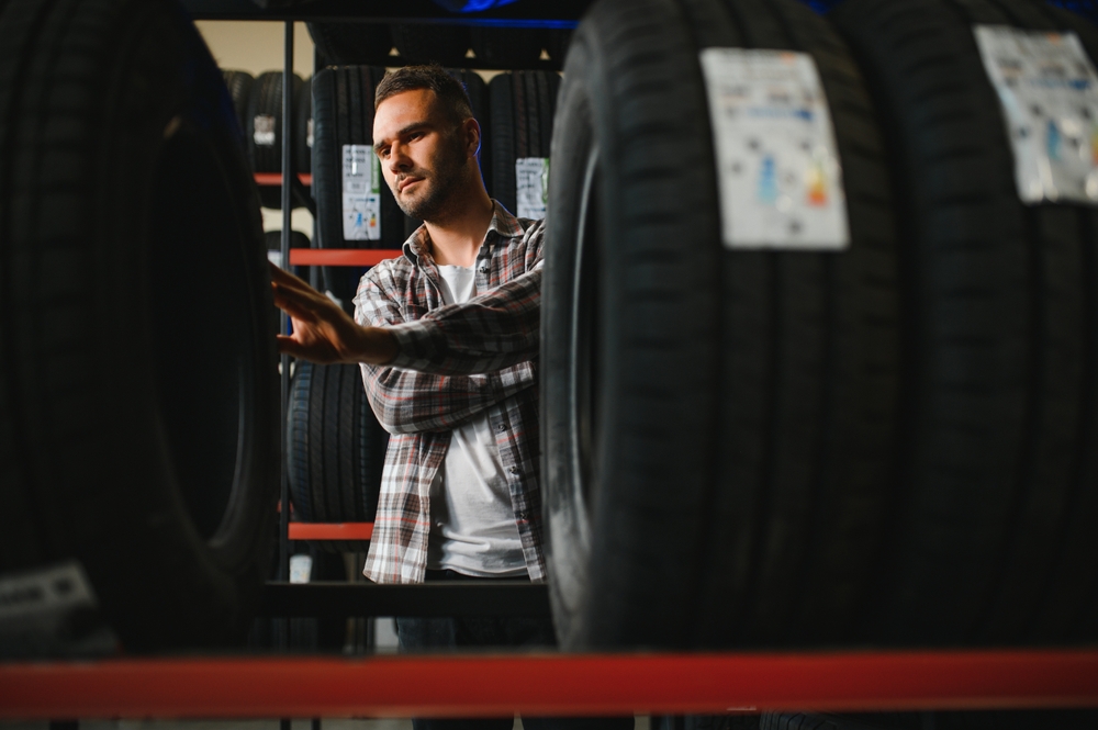 Young man buys new tires.